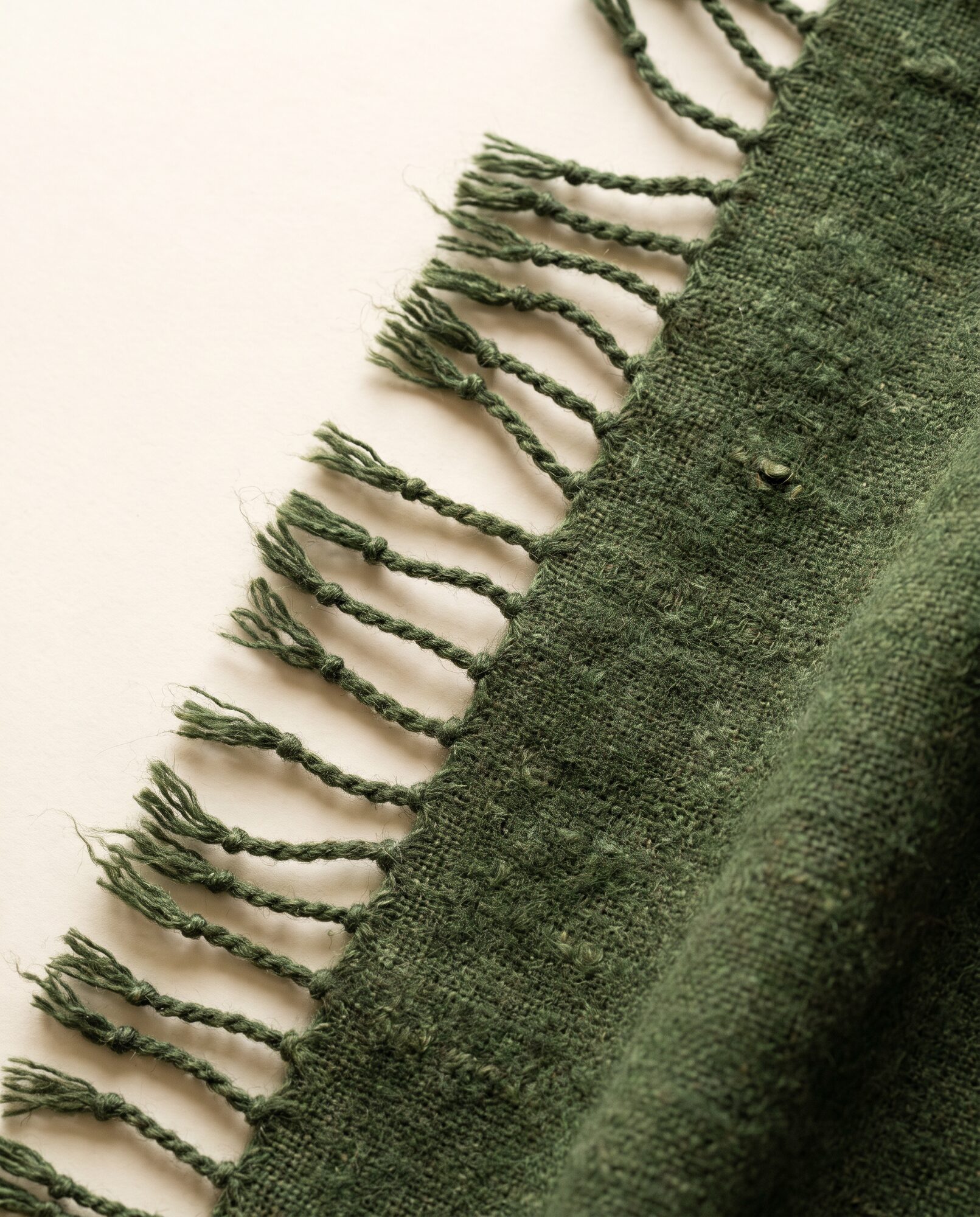 Close-up of moss khaddar showing the handloom slub and weave texture