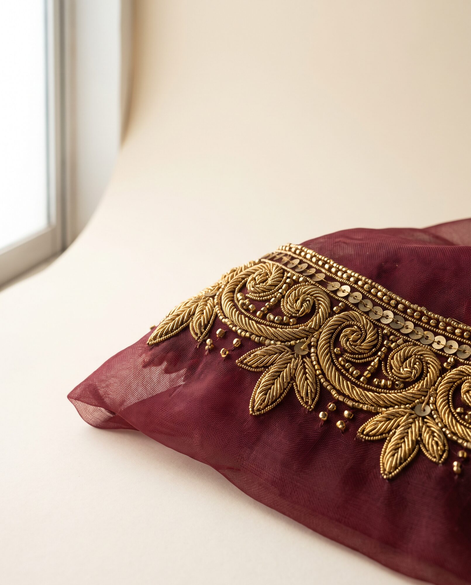 Close-up of maroon organza formal with raised zardozi hand embroidery worked on an adda frame
