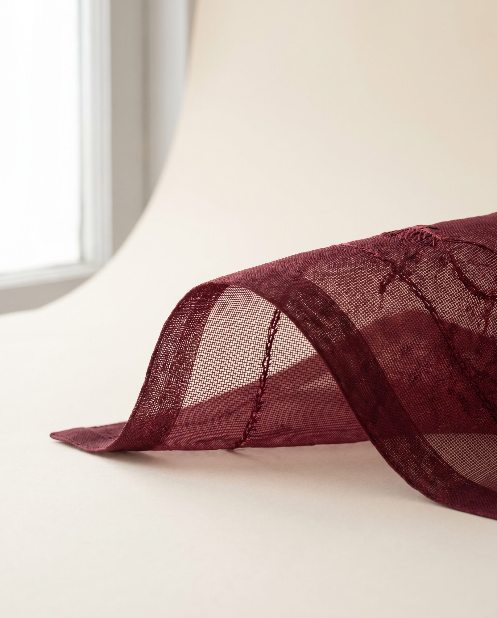 Maroon silk organza in close-up, showing the sheer weave
